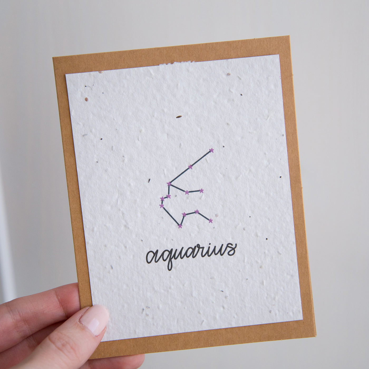 A greeting card with the Aquarius constellation and word “Aquarius” printed on plantable seed paper