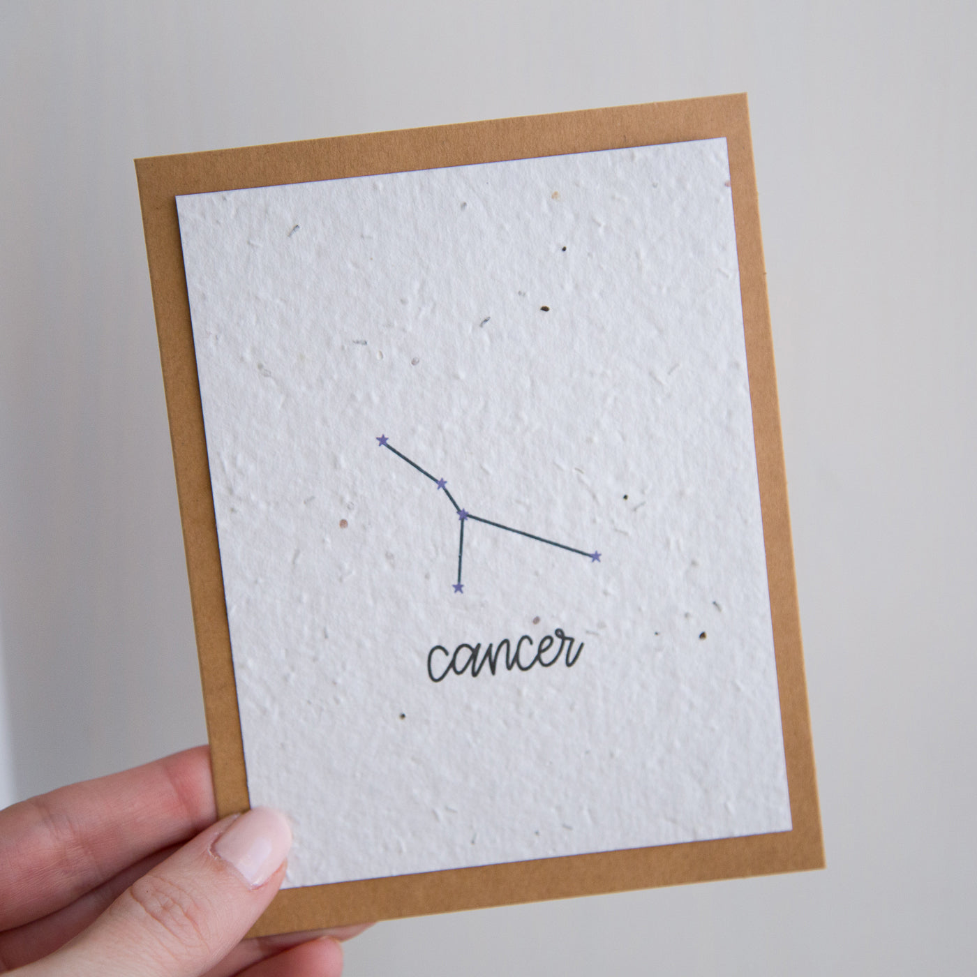 A greeting card with the Cancer constellation and word “Cancer” printed on plantable seed paper