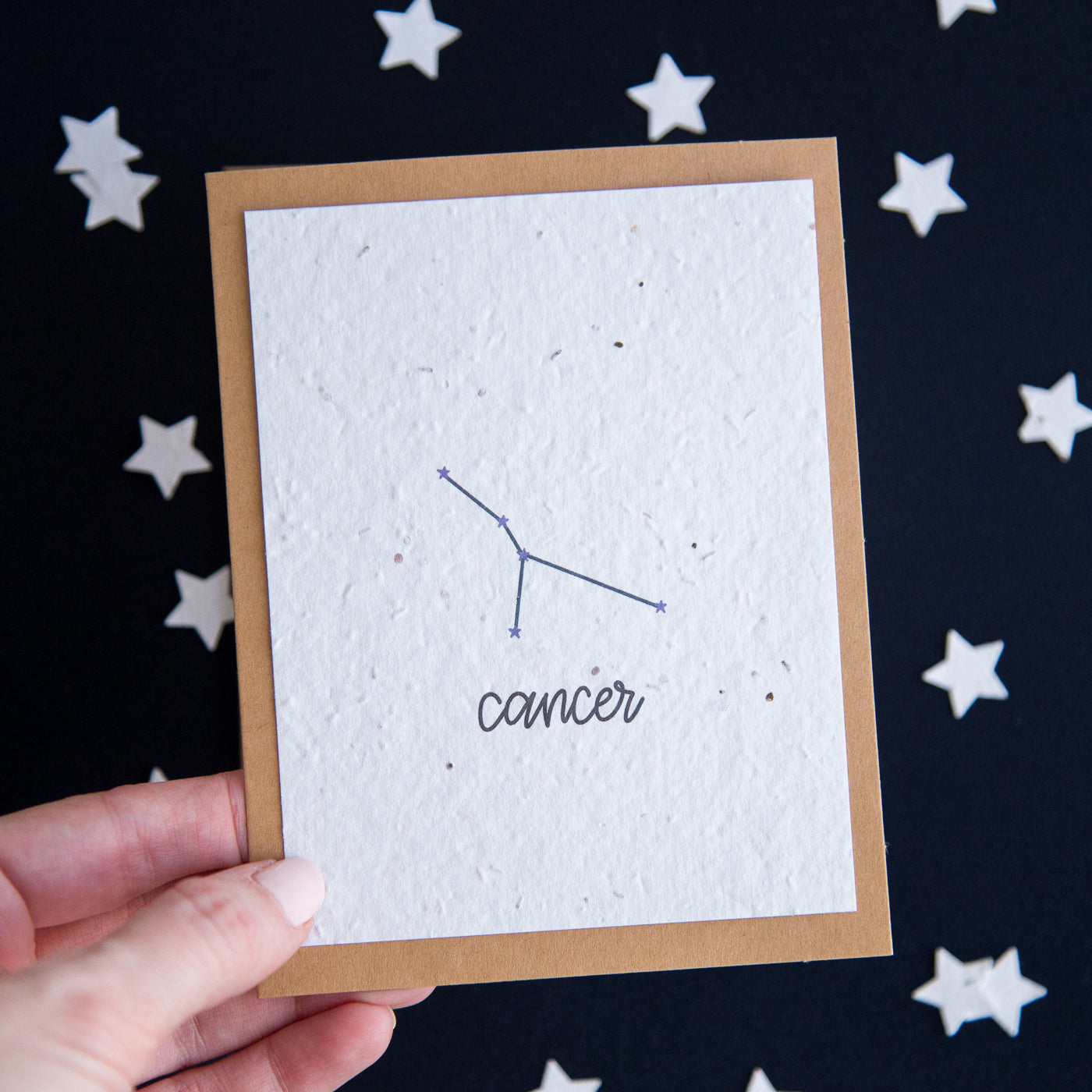 A greeting card with the Cancer constellation and word “Cancer” printed on plantable seed paper