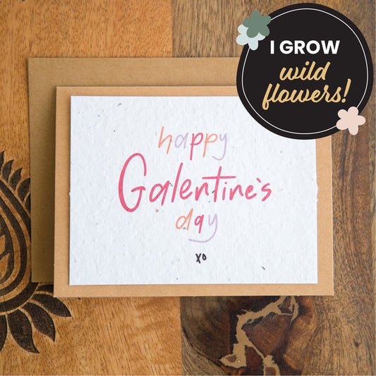 White greeting card with the words “happy Galentine’s Day xo” written in red orange and purple on plantable seed paper