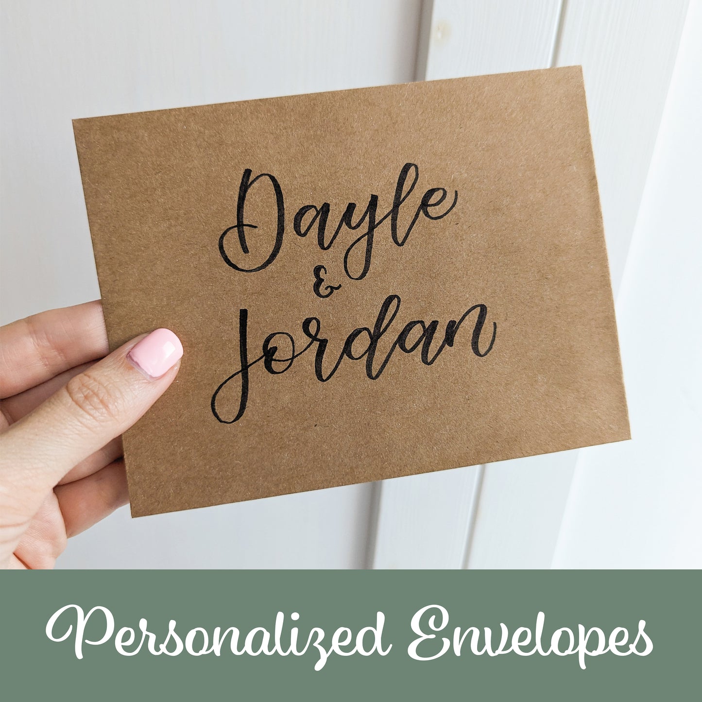 a hand holding an envelope with the names "Dayle & Jordan" handwritten in black calligraphy