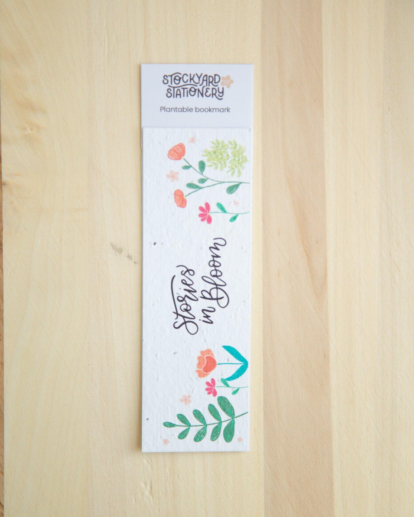 Plantable bookmark with floral design on a wooden surface