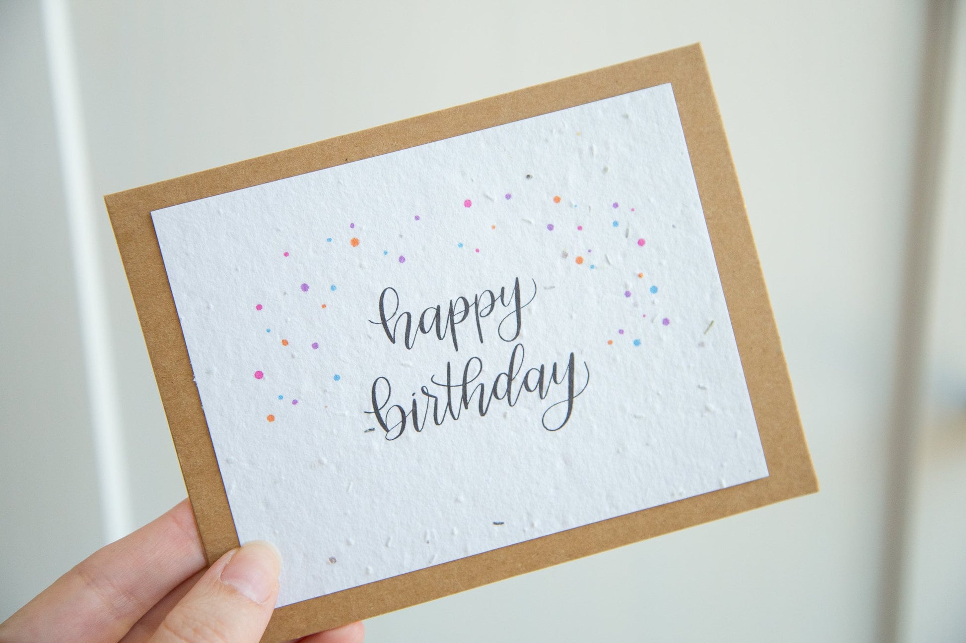 A2 sized greeting card printed on plantable seed paper with the words "happy birthday" and coloured confetti