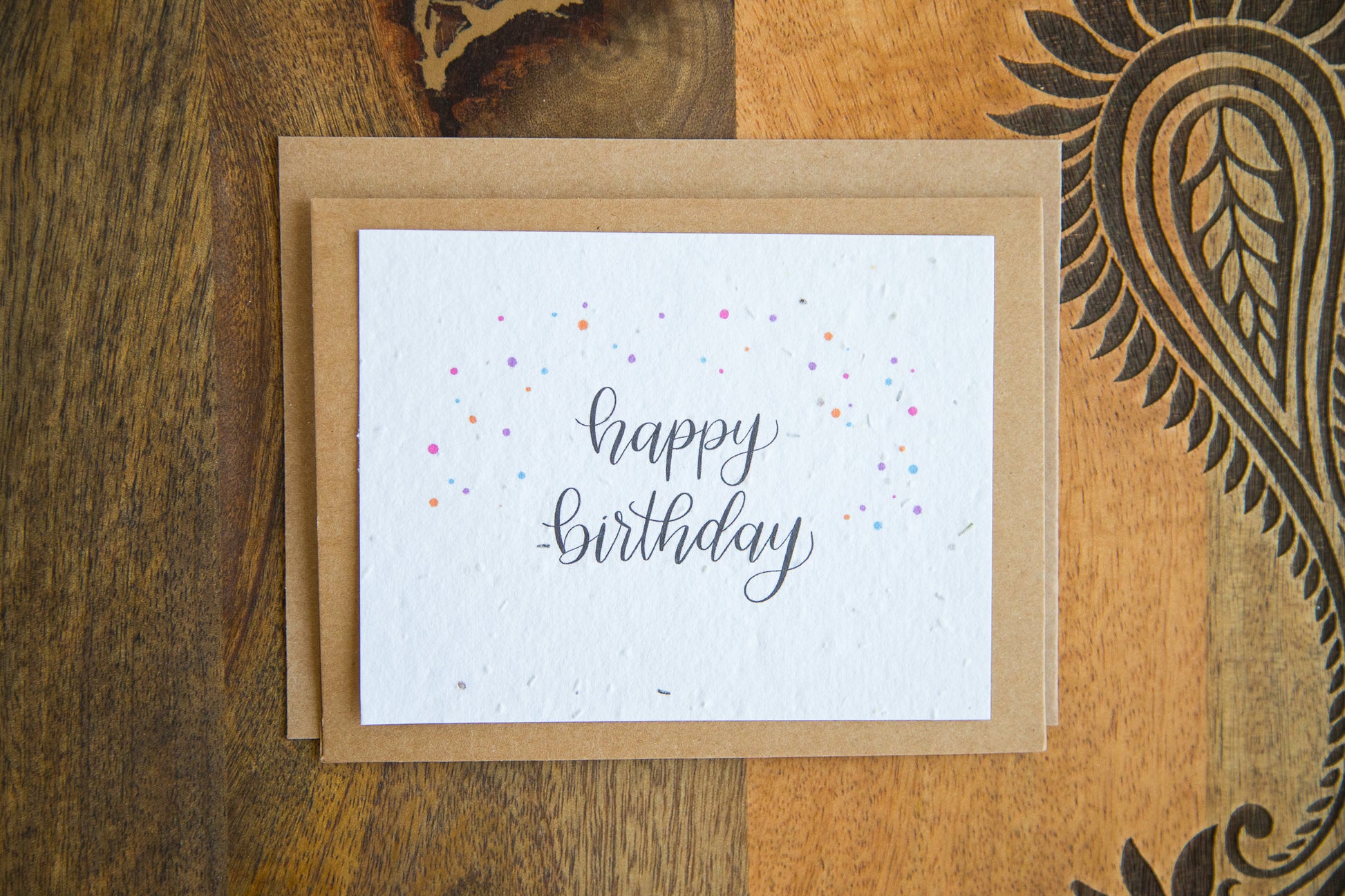 A2 sized greeting card printed on plantable seed paper with the words "happy birthday" and coloured confetti