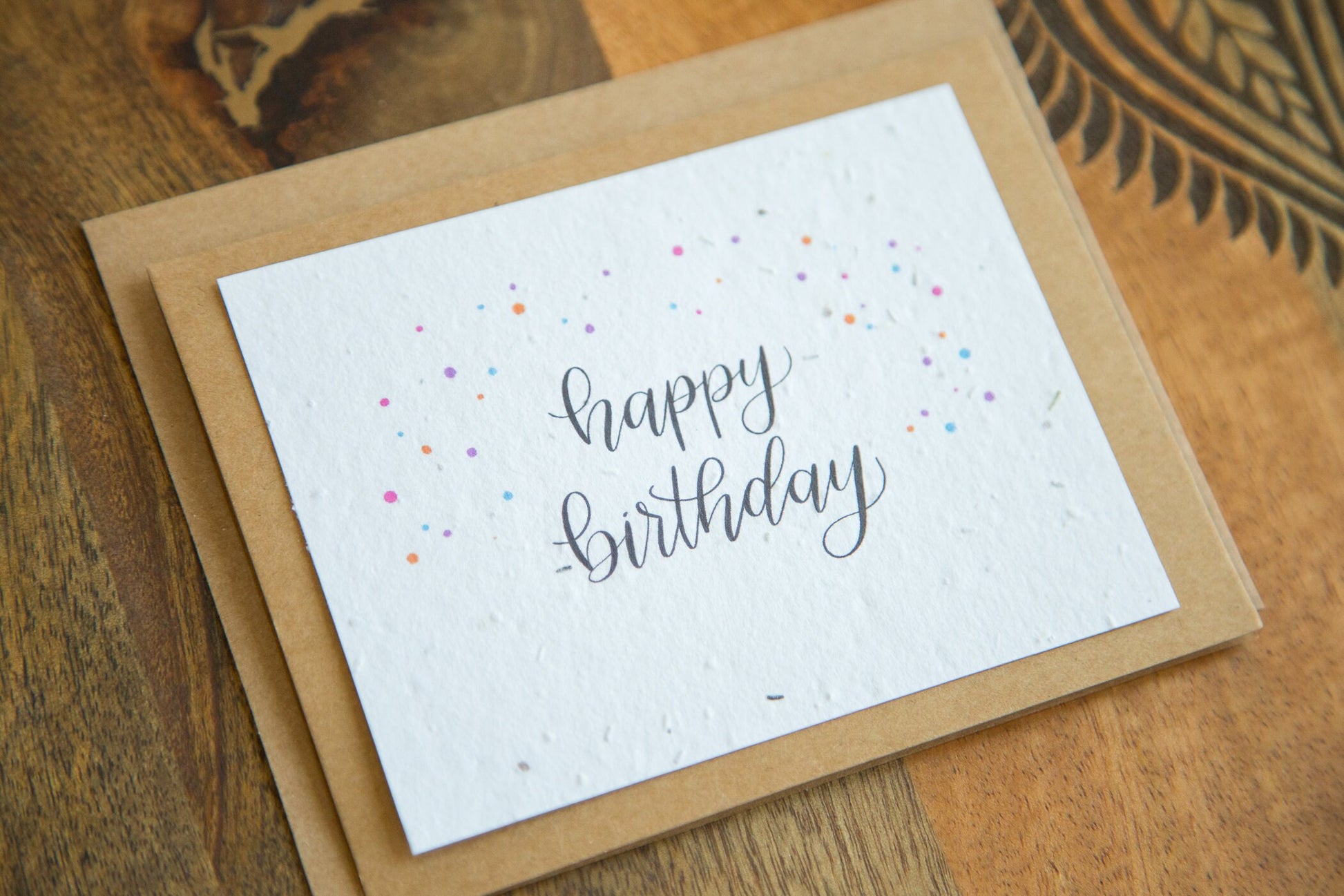 A2 sized greeting card printed on plantable seed paper with the words "happy birthday" and coloured confetti