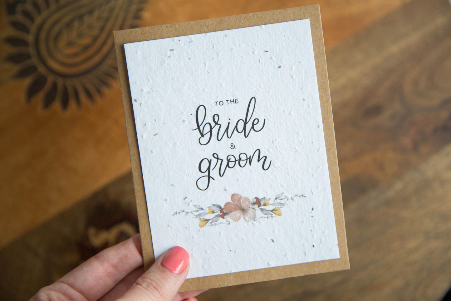 An A2 sized wedding card with floral designs and the text 'To the bride & groom' on the front, on white plantable seed paper