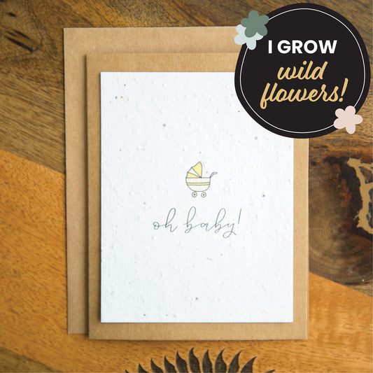 "oh baby" written in calligraphy on a plantable seed paper greeting card with an illustration of a yellow baby stroller